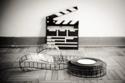 Cinema film reel and out of focus movie clapper board